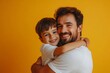 © Visual Venture - happy father's day! cute dad and son hugging on yellow background, Generative AI