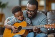 © Reeta - African dad teaching son how to play guitar on the sofa in the living room at home. Father's day, family bonding time concept, Generative AI