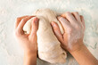 © Надежда Урюпина - hands in flour crumple the dough for pizza or pies, the process of cooking bakery products