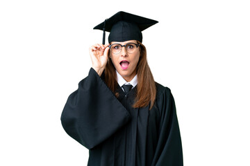 Canvas Print - Middle age university graduate woman over isolated background with glasses and surprised