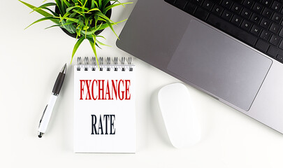 Poster - EXCHANGE RATE text on a notebook with laptop, mouse and pen .