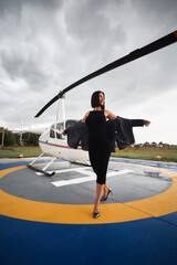 Busy successful woman boarding helicopter. business abroad. travel. lifestyle. young beautiful girl. photo shoot