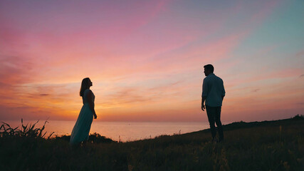 Wall Mural - man and woman in Pastel colored sunset sky background