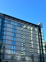 Canvas Print - Looking up at modern buildings with a clear blue sky background. Taken in Manchester England. 