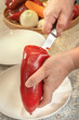© alexey_arz - Cook uses a knife to clean out the seeds from a red bell pepper for subsequent stuffing. Close-up