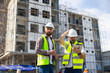 © NVB Stocker - Architect and contractor working on building in construction site. Two Professional Architects Engineer Working on Personal laptop computer at house construction site
