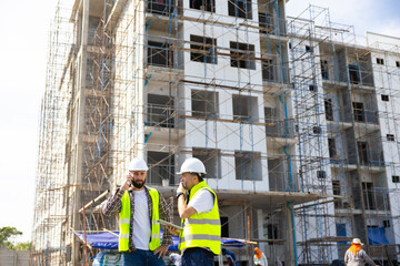 Architect and contractor working on building in construction site. Two Professional Architects Engineer Working on Personal laptop computer at house construction site