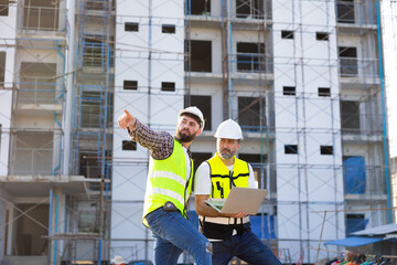 Architect and contractor working on building in construction site. Two Professional Architects Engineer Working on Personal laptop computer at house construction site