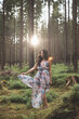 © Fauren - Pretty young brunette aged 20-25 is dancing around the forest in a colourful dress. Joy of clean air and the power of nature. Forest fairy