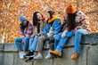 © Ladanifer - Happy multi-ethnic group of young hipster diverse student friends having fun while hanging out sitting together outdoors. Friendship concept.