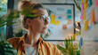 © Jirawatfoto - A woman using sticky notes in an office setting with plants and natural light.
