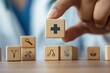 © Jennie Pavl - a hand holding a wooden block with a medical icon of a doctor, surrounded by other blocks with icons of medical equipment, representing the comprehensive coverage of health insurance