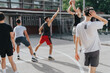 © qunica.com - A group of friends plays basketball on an old neighborhood court, capturing teamwork and competitive spirit in the summer sun.