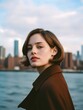 © VISUAL BACKGROUND - A woman standing in front of a body of water with a city in the background