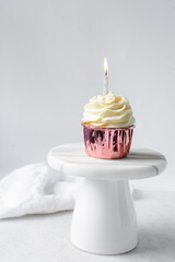 Sticker - Pink cupcakes with tall buttercream swirl on a cake stand, cupcakes in pink foil liners with vanilla buttercream and a lit candle, frosted cupcakes on a white background