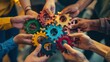 © florynstudio3 - Diverse hands holding colorful gears together, symbolizing teamwork and collaboration.