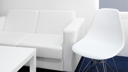 Aufkleber - A white couch and chair are in a room with a blue carpet. The room is very clean and organized, giving off a calm and peaceful atmospher