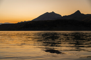 Wall Mural - bright orange sunrise over the lake and mountains.