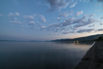 Wall Mural - beautiful sunrise with dramatic clouds over the lake and mountains.