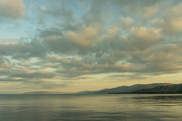 Wall Mural - beautiful sunrise with dramatic clouds over the lake and mountains.