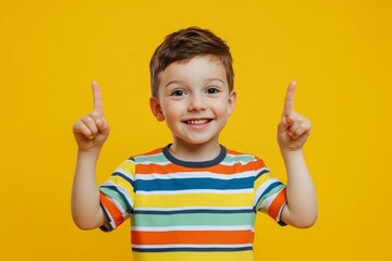 idea. child, boy emotionally points up. A gesture of an idea. Portrait of a child in a bright striped T-shirt on a yellow background, Generative AI