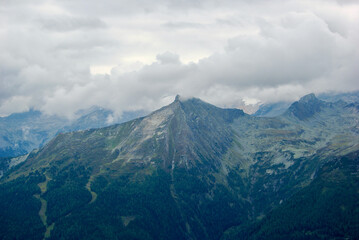Wall Mural - view of an amazing mountain landscape on a hazy day with gray clouds and fog over the peaks in autum