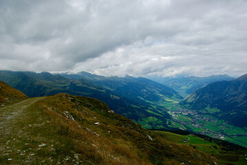 Wall Mural - view of an amazing mountain landscape with a village in the valley on a hazy day with gray clouds an