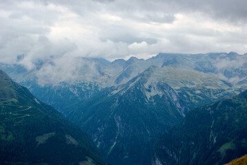 Wall Mural - view of an amazing mountain landscape on a hazy day with gray clouds and fog over the peaks in autum
