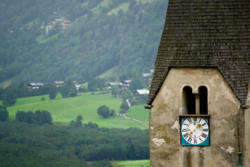 Wall Mural - view of a mountain landscape on a rainy day with mist over the valley beside a stone church tower in