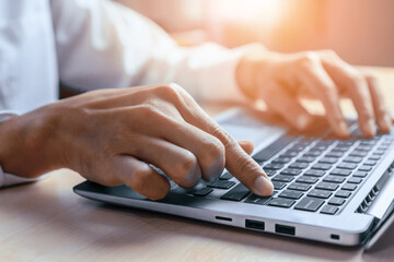 Wall Mural - Businessman hand typing on computer keyboard of a laptop computer in office. Business and finance concept. uds