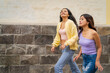 © Guillermo Spelucin - Two young women walking down the street in a town