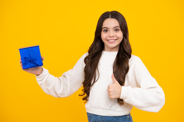 Wall Mural - Emotional teenager child hold gift on birthday. Funny kid girl holding gift boxes celebrating happy New Year or Christmas. Happy face, positive and smiling emotions of teenager girl.