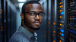 © Siasart Stock - Close-up portrait of a man in glasses standing in front of a server rack.