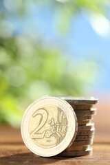 Wall Mural - Stacked euro coins on wooden table, closeup