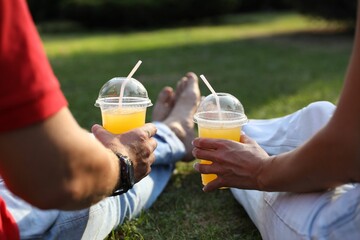 Canvas Print - Couple spending time together on green lawn in park, closeup