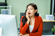 © M+Isolation+Photo - Yawn, sleepy of young Asian businesswoman in a formal suit experiences office syndrome and pain while working at desk in a modern glass office, consulting on diverse business topics