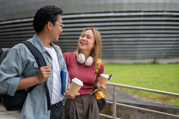 A happy Asian female student is enjoying a conversation with her male friend while walking outdoors.