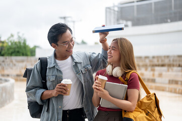 Wall Mural - A lovely young Asian college student couple is walking together outdoors on a sunny day on campus.