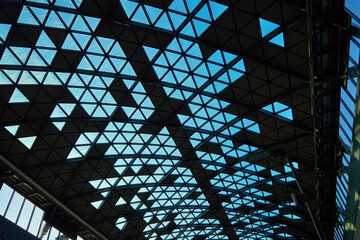 Wall Mural - Modern glass ceiling with triangular pattern against blue sky. Contemporary building details. Abstract architecture