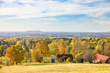 Wall Mural - Red cottage and a barn in a beautiful landscape view at autumn