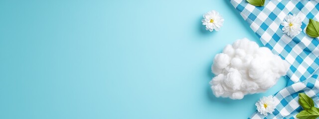 Wall Mural -  A blue-and-white checked tablecloth with cotton blooms and foliage adorns it, against a light blue backdrop