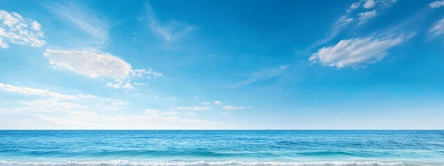 Poster - Ocean with a blue sky, dotted by clouds