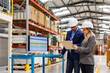 © Halfpoint - Female engineer and male project manager standing in modern industrial factory by computer, talking about production. Team management in manufacturing facility