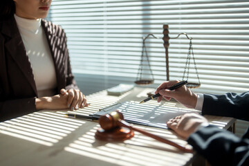 Lawyer explaining divorce agreement and showing where to sign with pen