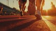 © fotofabrika - Runners sprinting on a track under a vibrant sunset at an outdoor stadium during a summer evening training session
