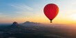 © WD Stock Photos - A beautiful sunrise landscape with a red hot air balloon in sky