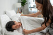 © Kawee - Asian young wife put blanket on sick husband with fever sleeping on bed.