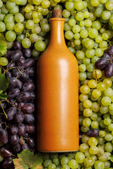 A wine bottle lies elegantly over a bed of fresh grapes