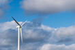 © yaqui_villegas - A lone wind turbine stands tall against a backdrop of clouds in a blue sky, symbolizing the solitary strength and commitment to renewable energy and a sustainable future in Tarragona Spain