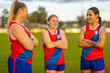 © Austockphoto - three young women on football field with their arms crossed